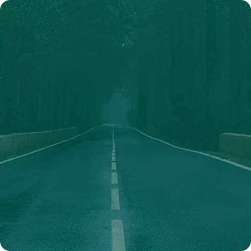 Empty road disappearing into teal fog